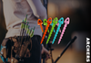 Colorful archery pins displayed in front of a person holding a bow.