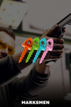 TargetTacks in orange, green, teal, and pink overlaying a gun held by a person with 'MARKSMEN' label beneath.