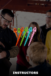 Group of people with colorful plastic tools, possibly teaching or demonstrating something.